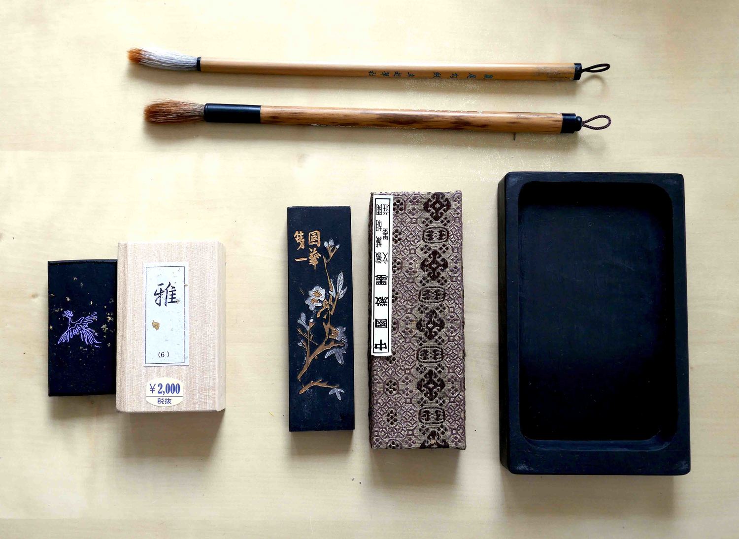 Tools of the trade: beautifully embossed ink sticks, a simple ink stone, and bamboo brushes. 